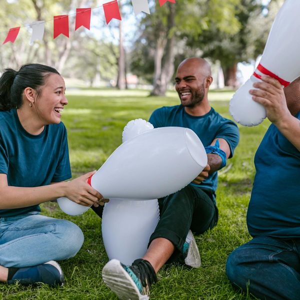A group of diverse people laughing and exercising together in a park.