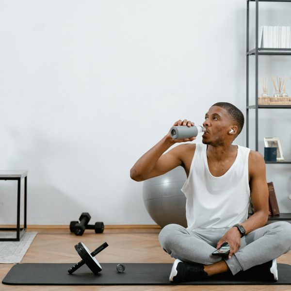 A neat setup with a yoga mat, a water bottle, and headphones.